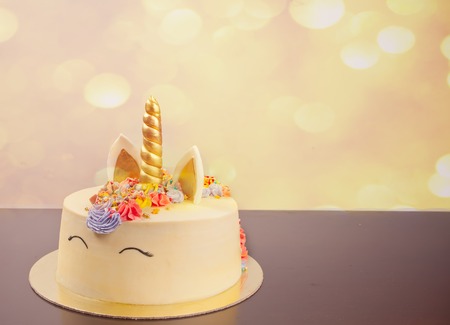 Homemade cake in the form of a unicorn with cream colored flowersの写真素材