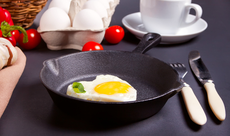 Heart shape scrambled eggs on iron dark panの写真素材