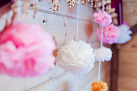 Festive decoration of paper pink and white pompons on a wallの写真素材