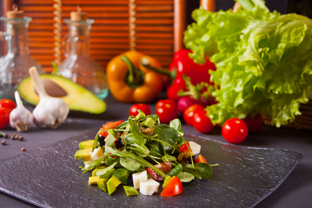 Fresh mixed vegetables salad on a plate on the vegetables on the backgroundの写真素材