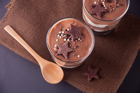 Chocolate dessert in glass jars on a black tableの写真素材