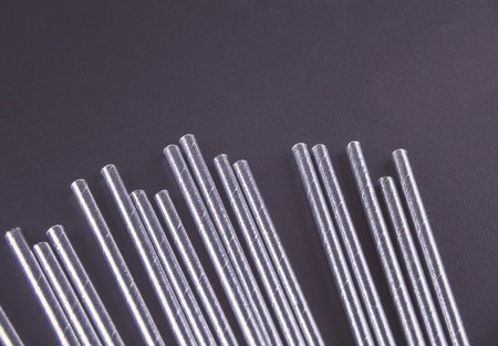 Drinking paper straws for summer cocktails on black background. Top view.の写真素材