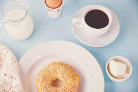 Fresh healthy bagel on the white plate on the blue table.の写真素材