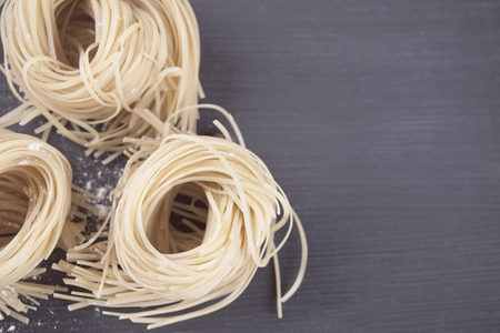 Italian egg pasta nest tagliatelle on the kitchen tableの写真素材