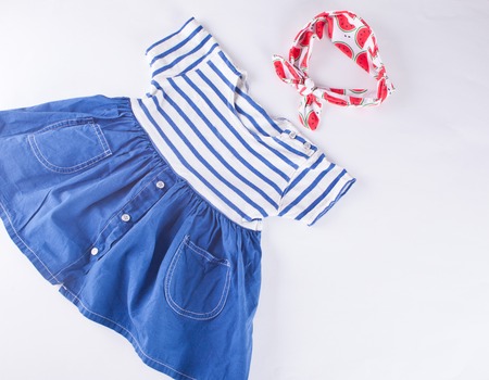 Baby striped dress in a marine theme and accessorie - headband on the blue background. Top view.の写真素材