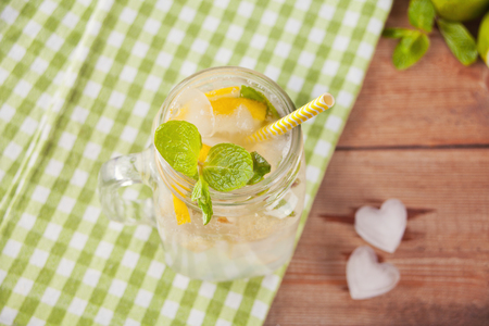 Lemonade or mojito cocktail with lemon and mint, cold refreshing drink or beverage with ice heart shaped . Top view.の写真素材
