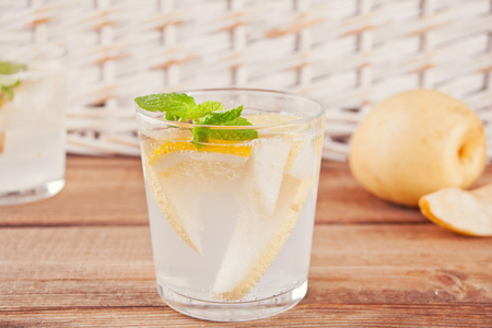 Pear Lemonade or mojito cocktail with lemon and mint, cold refreshing drink or beverage with ice.の写真素材