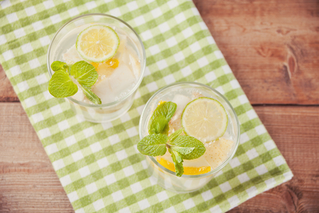 Lemonade or mojito cocktail with lemon and mint, cold refreshing drink or beverage with ice. Top view.の写真素材