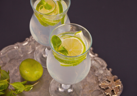 Lemonade or mojito cocktail with lemon and mint, cold refreshing drink or beverage with ice.の写真素材
