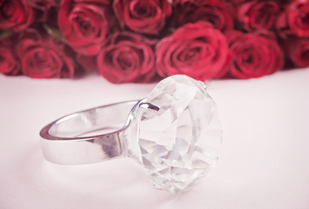 Diamond giant ring and red roses in the backgroundの写真素材