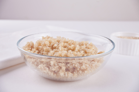 Cooked delicious quinoa in a glass bowl on the white tableの写真素材