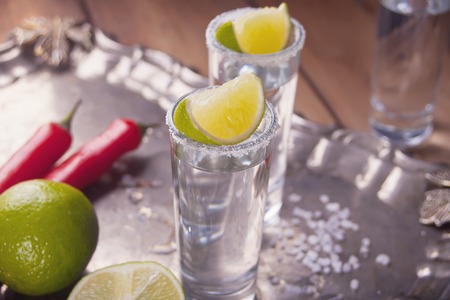 Tequila shot with lime and red pepper and sea salt on trayの写真素材