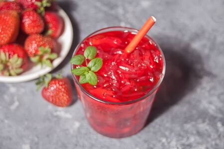 Glass with fresh homemade strawberry sweet iced tea or cocktail, lemonade with mint. Refreshing cold drink. Summer party.の写真素材