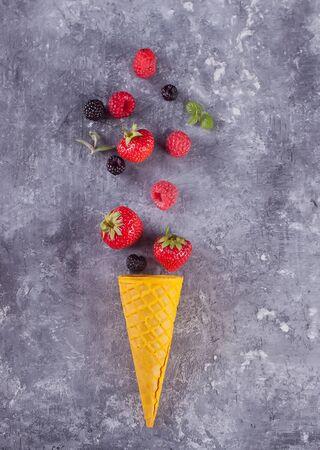 Strawberry in waffle yellow cone on a concreate background. Top view.の写真素材