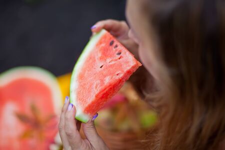 Woman with a piece of ripe watermelon in a picnic. Autumn harvest. Autumn concept.の写真素材