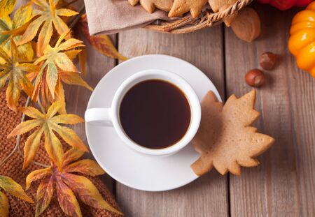 Composition with cup of coffee, autumn leaves, pumpkin, homemade cookies on the wooden table. Autumn concept. Top view.の写真素材
