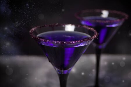 Two glasses with purple cocktail for Halloween party on the dark background. Top view.の写真素材