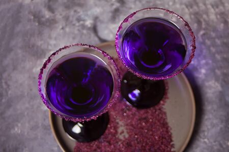 Two glasses with purple cocktail for Halloween party on the dark background. Top view.の写真素材