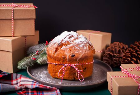 Traditional Christmas cake panettone with fruits and nuts with Christmas decoration.