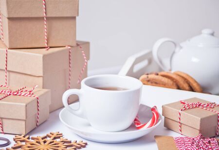 Cup of tea, homemade cookies, Christmas gift boxes and Christmas decor on the white backgroundの写真素材