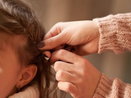 Mother braided pigtails her daughterの写真素材