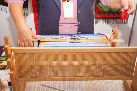 Woman hand weave on the weaving machine.の写真素材