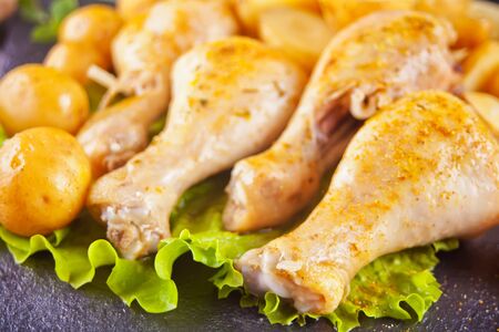 Roasted chicken legs with potato, spices and herbsの写真素材