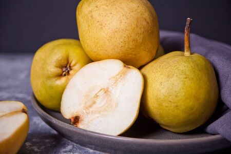Ripe pears in a plate on dark background.の写真素材