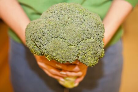 Young woman shopping healthy food in supermarket. Female hands holding broccoli. Health food concept.の写真素材