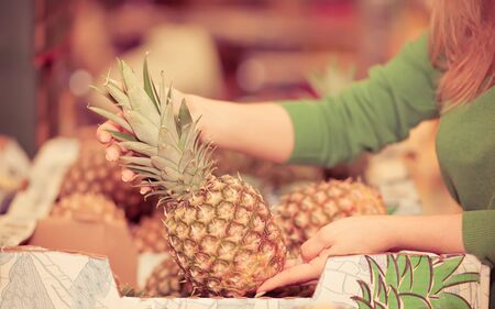 Young woman buying pineapple in a supermarketの写真素材