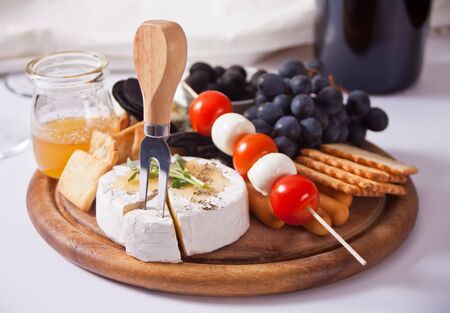 plate with assorted cheese, fruit and other snacks for partyの写真素材
