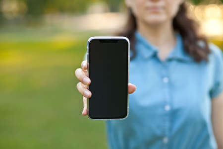 Woman showing blank mobile smartphone screen.
