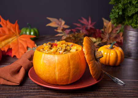Fresh cooked pumpkin soup served in a pumpkin. Autumn warm and cozy food.の写真素材