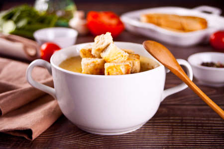 Cheese or onion cream soup with toasts bread in a white bowlの写真素材