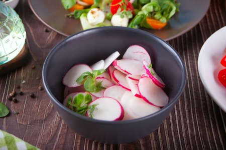 Spring fresh salad with radish and basil on the dinner tableの写真素材