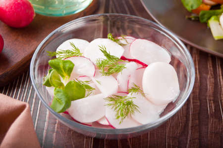 Spring fresh salad with radish and basil on the dinner tableの写真素材