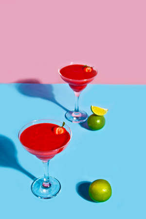 Cold strawberry margarita or daiquiri cocktails in a glasses with lime and rumの写真素材