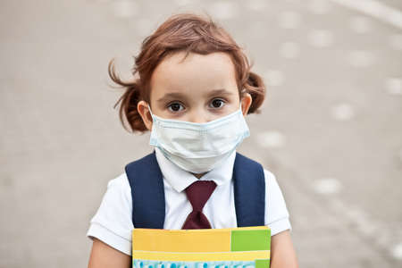 Concept of coronavirus COVID-19. Schoolgirl wearing medical face mask to health protection from influenza virusの写真素材