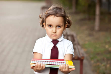 little cute schoolgirl in uniform with school books