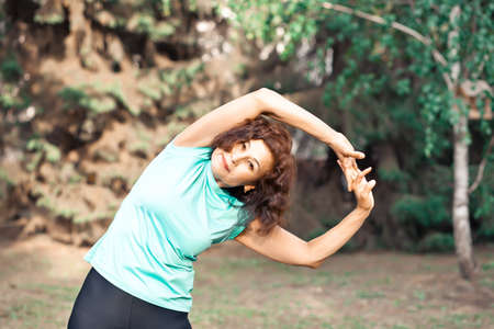Middle aged elderly active woman doing exercise in a park outdoor