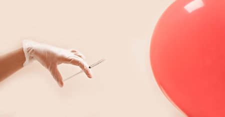 Concept with syringe and hand in gloves injecting a balloon. Spa, medicine, healthcare, treatment, beauty conceptの写真素材