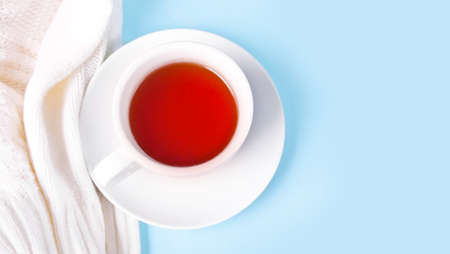 Hot winter cup of tea with white sweater or plaid nearby. Warm and cozy. Copy space.の写真素材