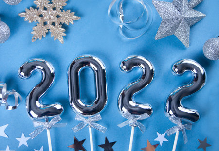 Christmas decoration with silver toys, stars, balls and 2022 numbers. Top view.