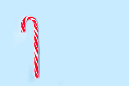 Candy cane on the blue background. Top view. Copy space.の写真素材