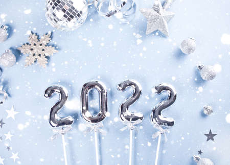 Christmas decoration with silver toys, stars, balls and 2022 numbers. Top view.