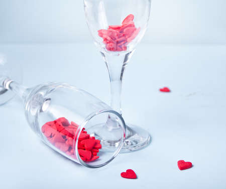 Two champagne glasses with red heart shaped candy. Valentines Day concept.の写真素材