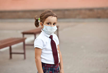 Schoolgirl wearing medical face mask to health protection from influenza virusの写真素材