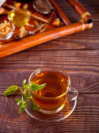 Cup of herbal mint tea with dry herbs on the tray.の写真素材