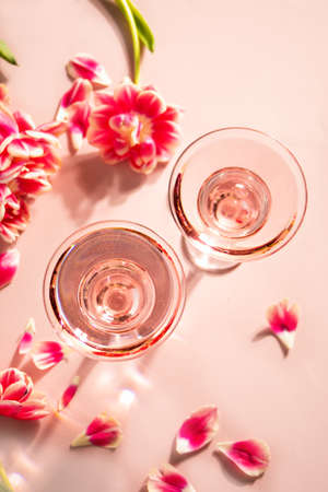 Glasses of pink cocktail with flowers and petals. Birthday party or Valentines day romatic couple concept.の写真素材