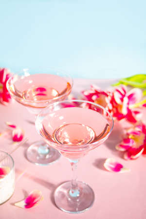 Glasses of pink cocktail with flowers and petals. Birthday party or Valentines day romatic date couple concept.の写真素材